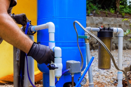Plumber connecting a whole-home water filter to the main water line in a Brighton